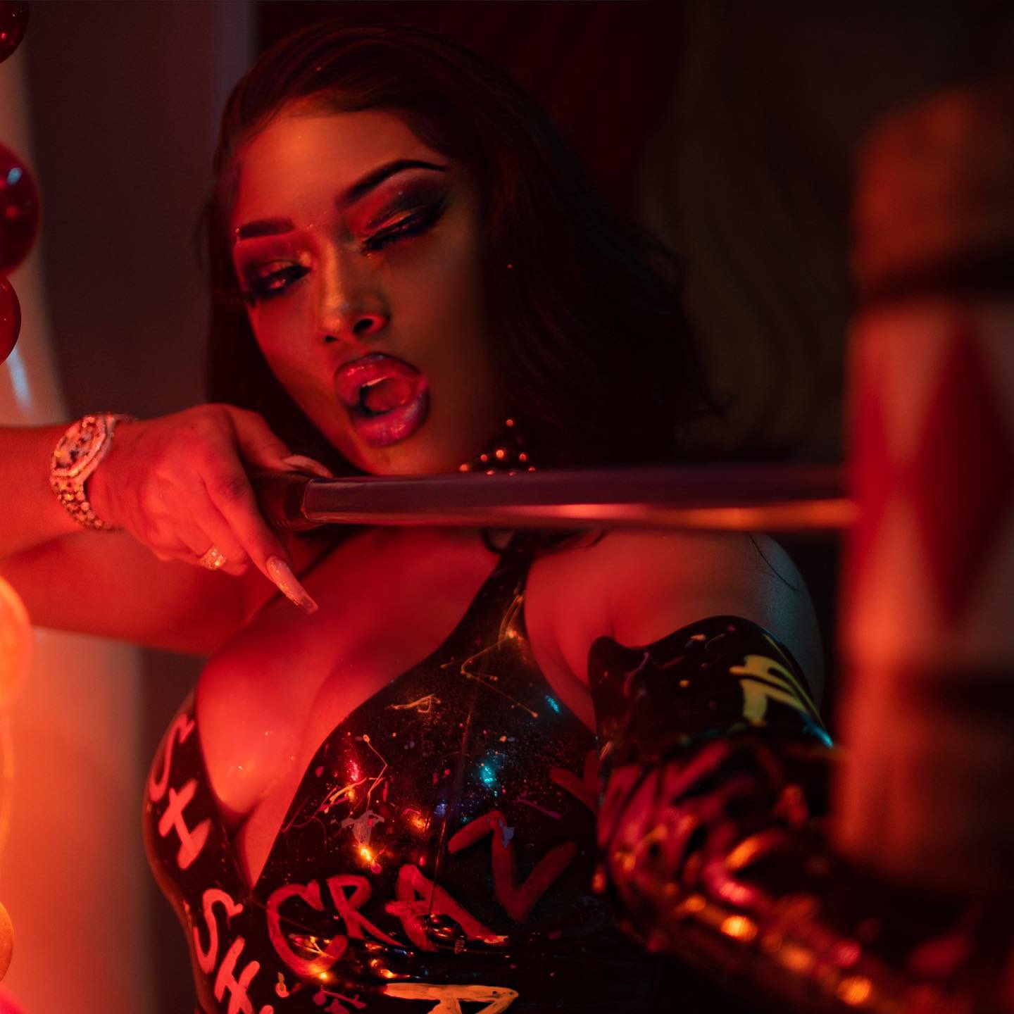 Megan Three Stallion reproduzindo a pose clássica da Arlequina