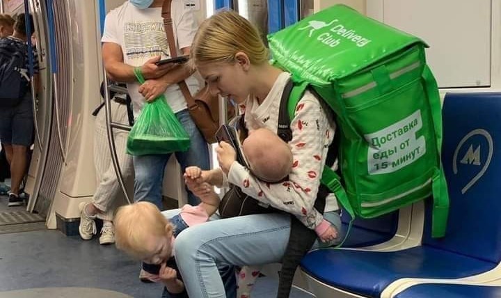Flagra de entregadora carregando as filhas durante o trabalho viraliza: “Para sustentá-las”